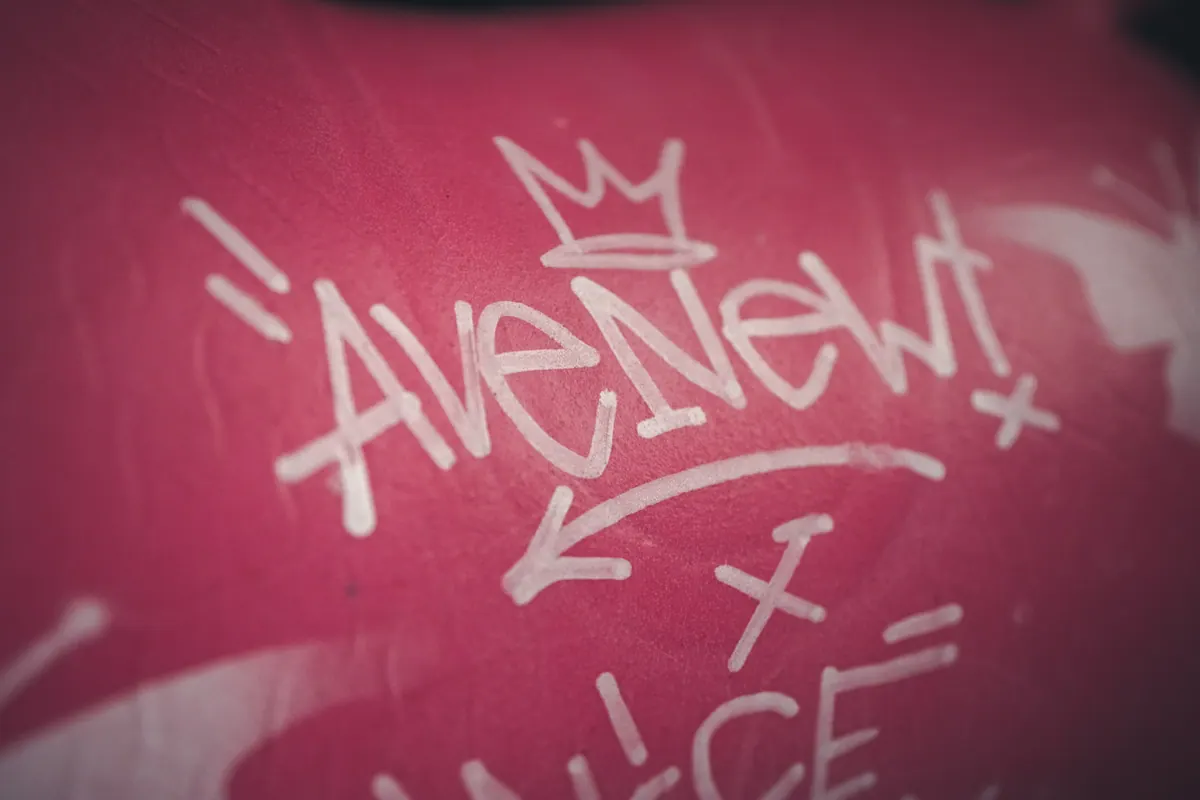 Graffiti AVENEW na różowej ścianie